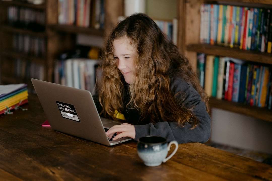 жена в черно яке, използваща macbook pro онлайн пъзел