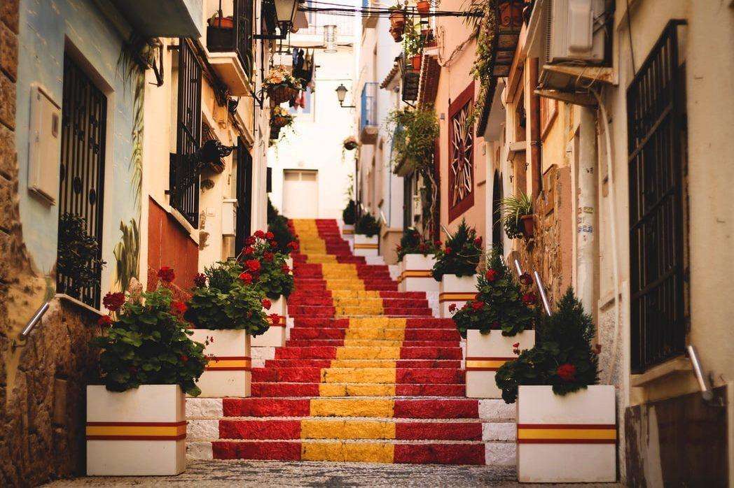 Byggnader med en smal gata med trappor i Spanien Pussel online