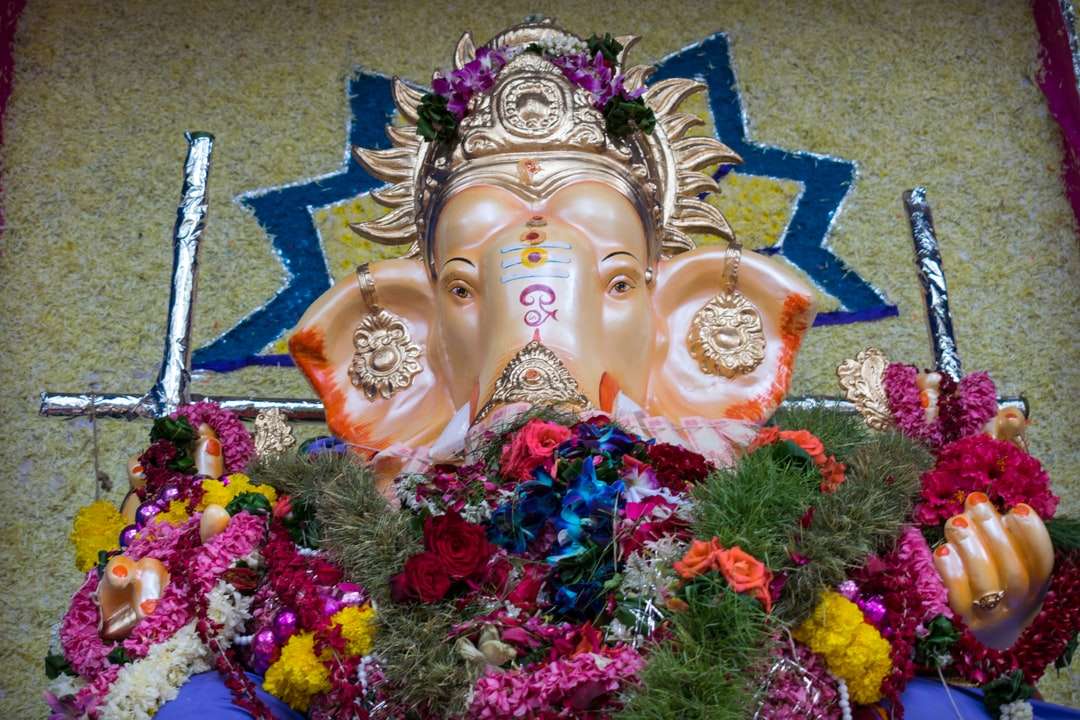 златна статуетка на Буда върху розови и сини цветя онлайн пъзел