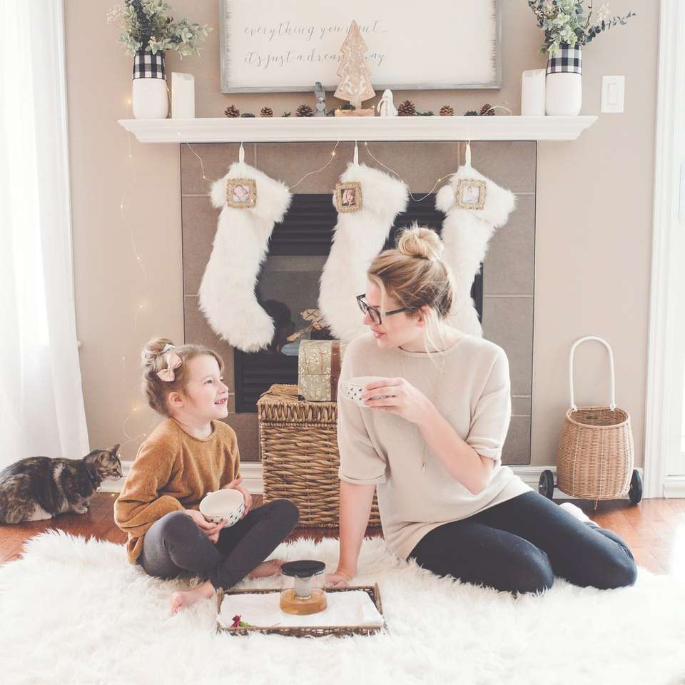 жена и момиче, седнали върху бял килим онлайн пъзел