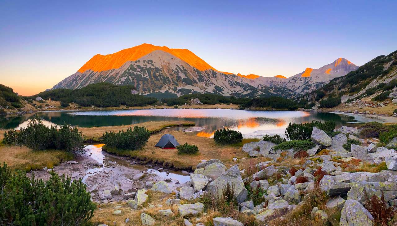 Coucher du soleil sur le lac Muratovo dans la montagne de Pirin puzzle en ligne