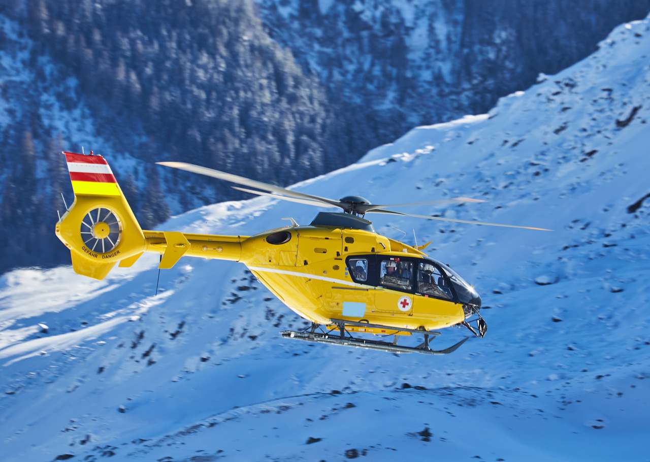 gelber Hubschrauber auf dem Hintergrund der schneebedeckten Berge Online-Puzzle