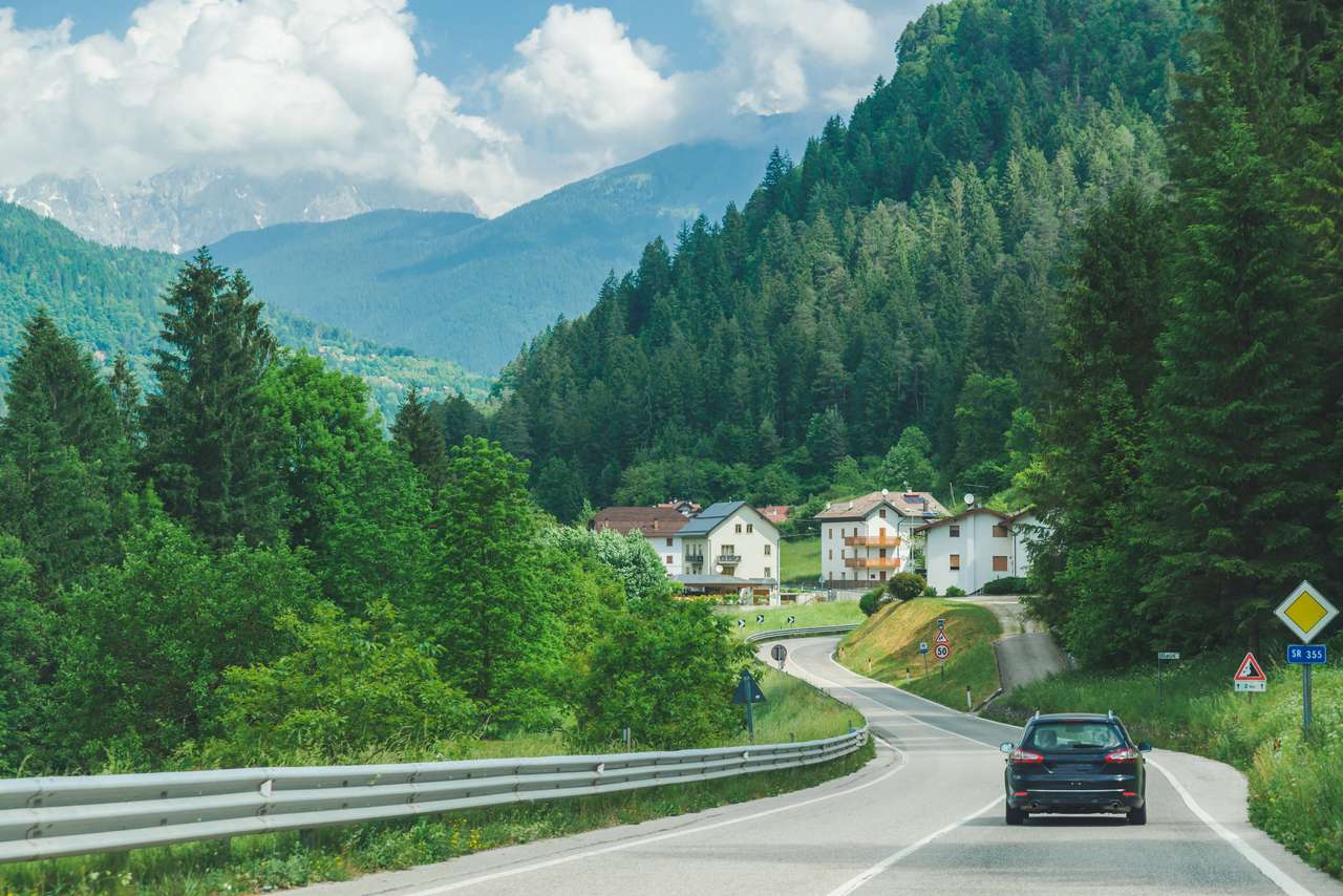 Подорож на автомобілі через маленьке містечко в горах пазл онлайн