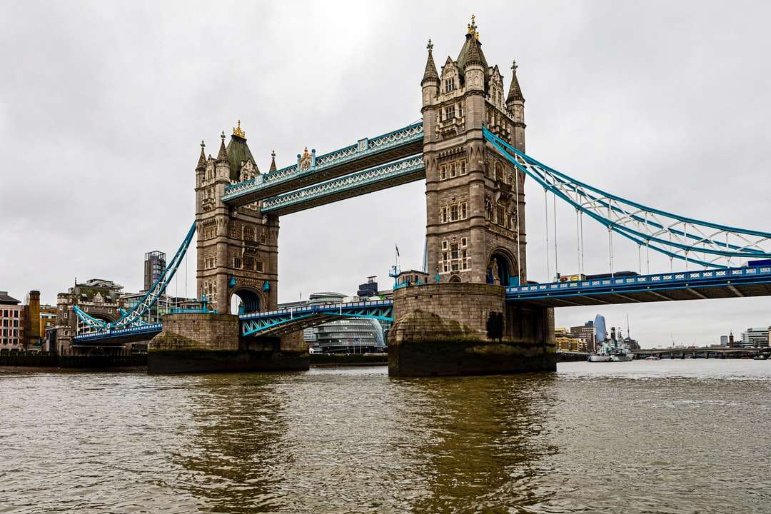 hnědý betonový most přes řeku pod bílými mraky skládačky online