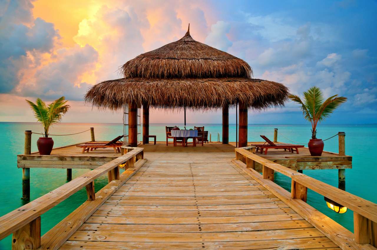 Tropische hut op het water bij zonsondergang legpuzzel online