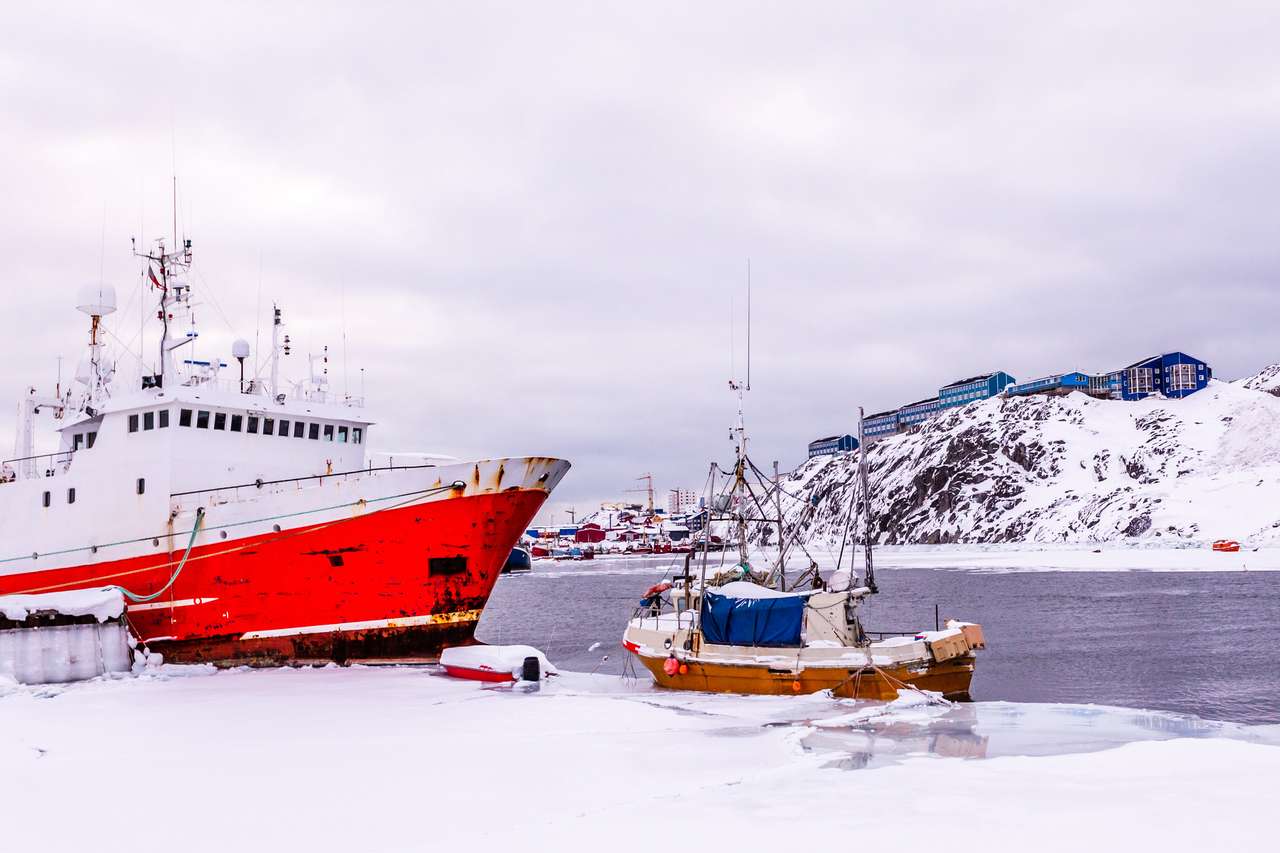 雪のラグーンに停泊している赤い漁船。 オンラインパズル