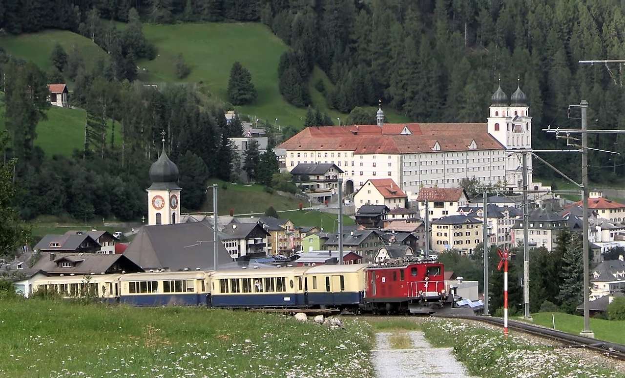 Train nostalgique devant le monastère de Disentis puzzle en ligne