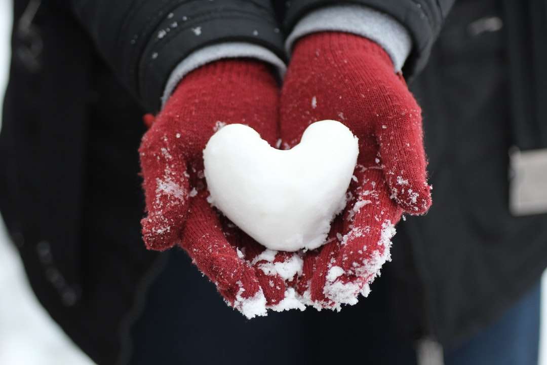 persona sosteniendo nieve en forma de corazón rompecabezas en línea