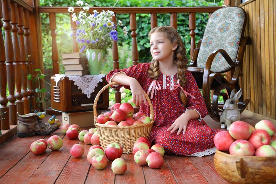 リンゴのバスケットでポーズをとる女の子 ジグソーパズルオンライン