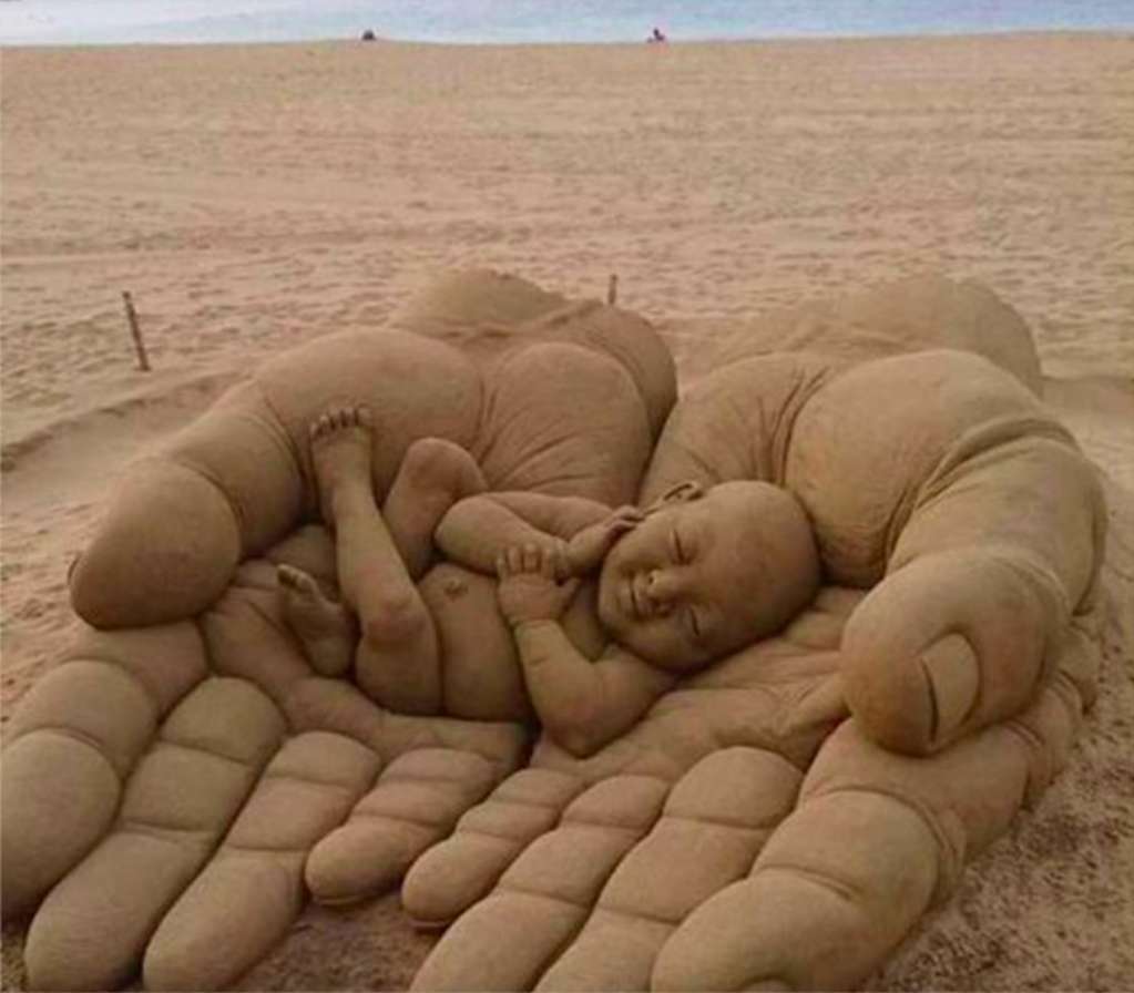 A sand sculpture of a baby in the palm of your hand online puzzle