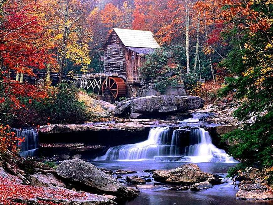 Herbst. Eine Mühle zwischen Bäumen und einem kleinen Wasserfall Puzzlespiel online