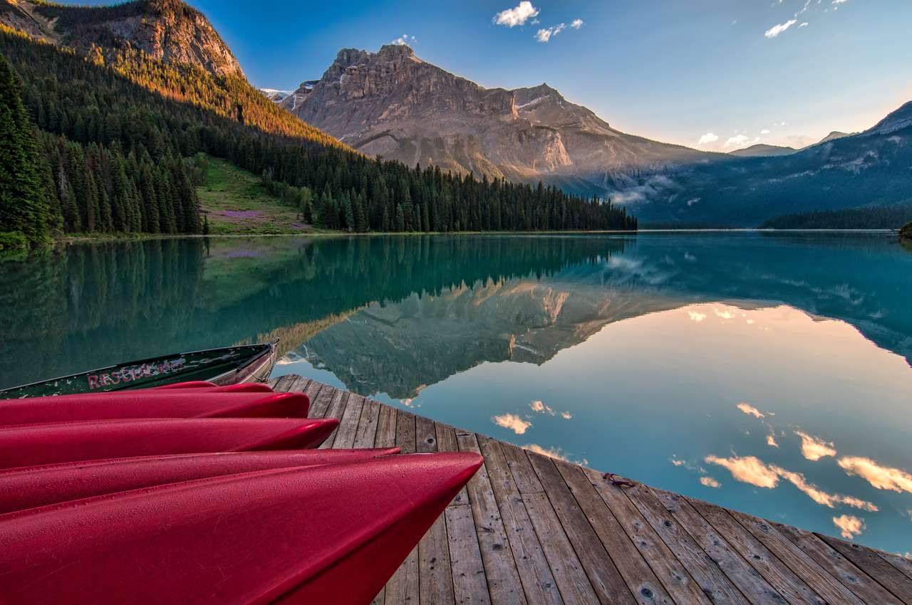 Lago nas montanhas. Um cais com canoas quebra-cabeças online