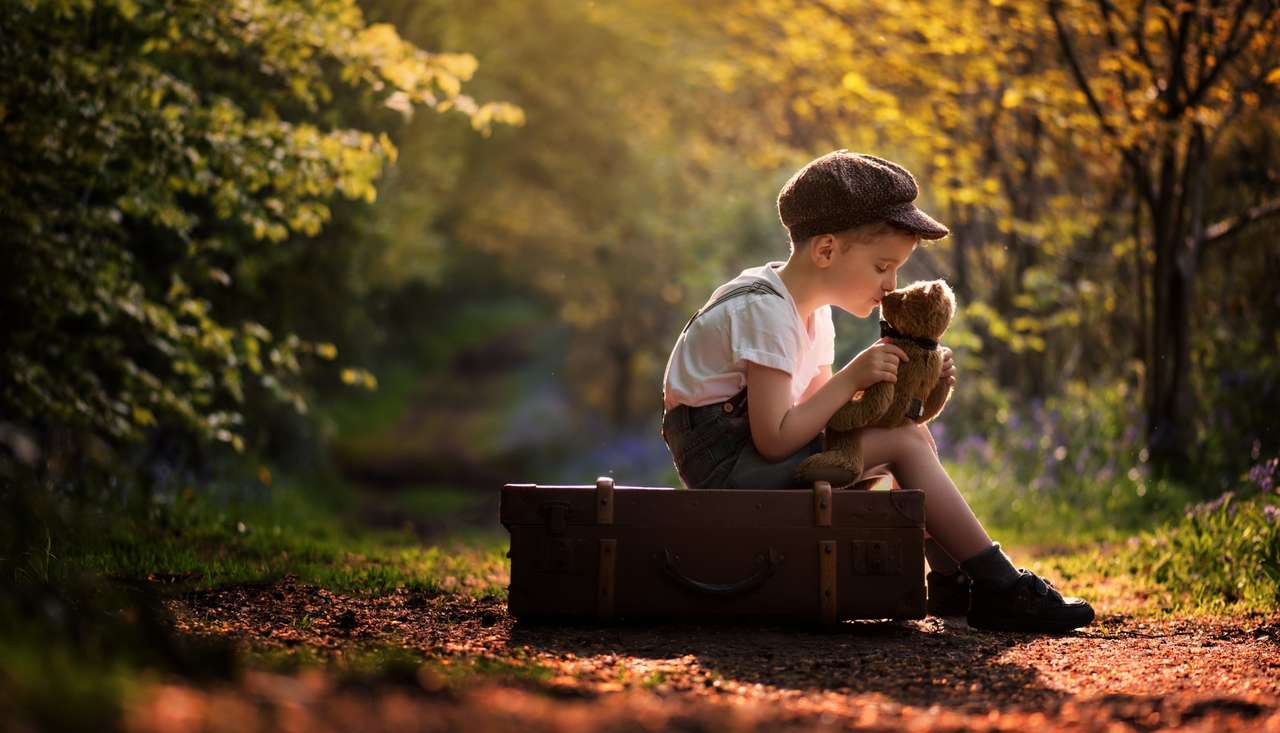 Babyjunge mit Teddybär sitzt auf einem Koffer Online-Puzzle