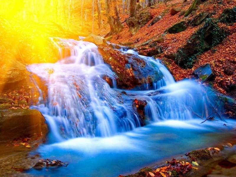 Ett vackert vattenfall- Ett vackert vattenfall i solen Pussel online