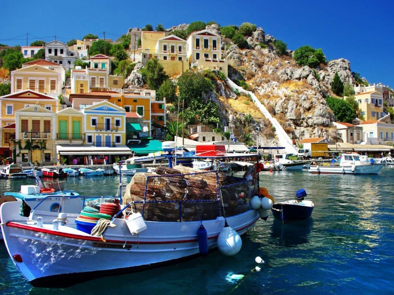 Греція-гарні будинки на скелі, диво краєвиду пазл онлайн
