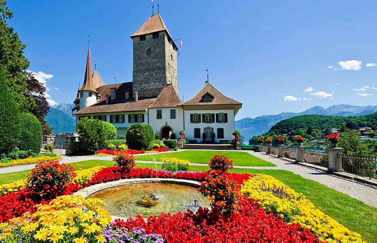 Schweiz- Spiez slott med en vacker trädgård Pussel online