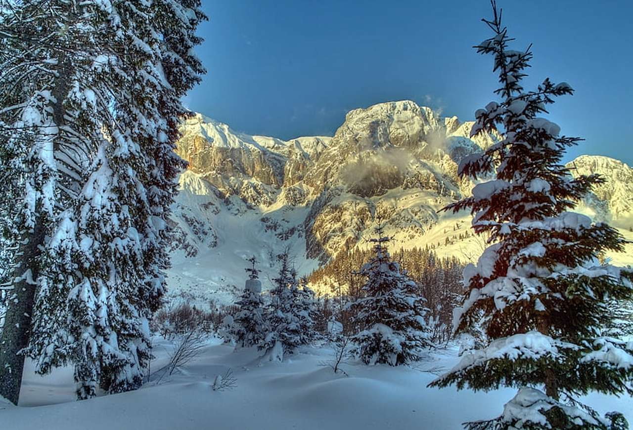 Vinterns skönhet i bergen upplysta av solen, ett mirakel pussel på nätet