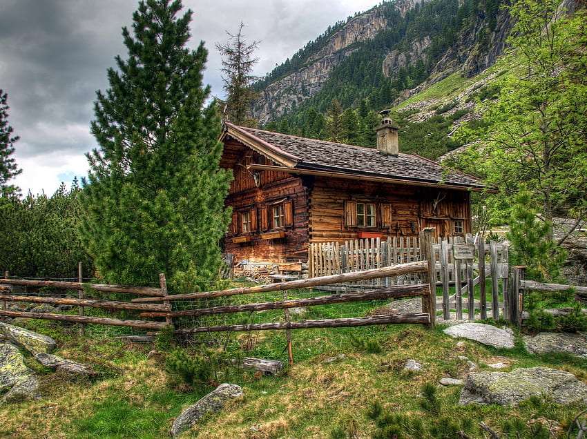 Деревянный забор, деревянный дом у подножия гор пазл онлайн