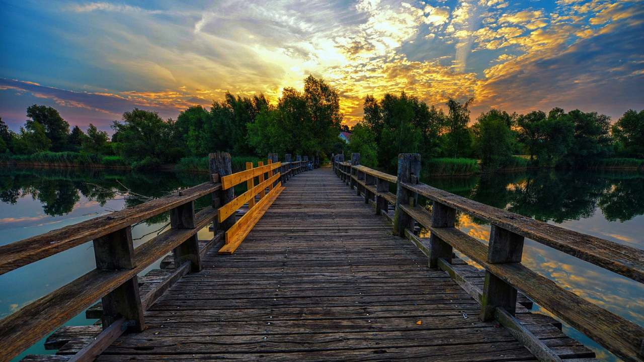 Brücke über den Fluss bei Sonnenuntergang Puzzlespiel online