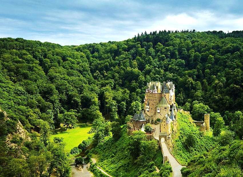 Ett slott på toppen av ett berg bland grönska Pussel online