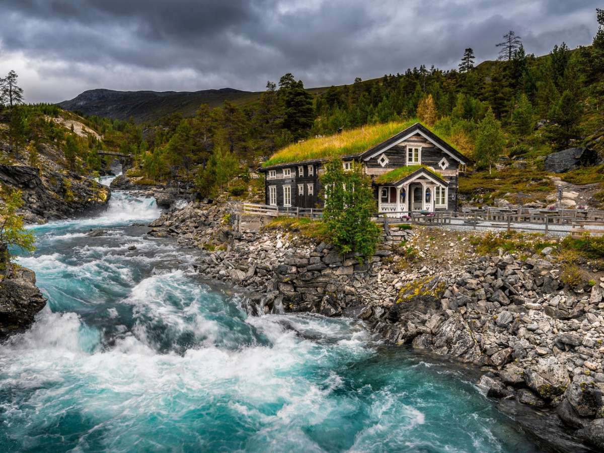 Norge-Eco-hus vid en forsande fjällbäck pussel på nätet