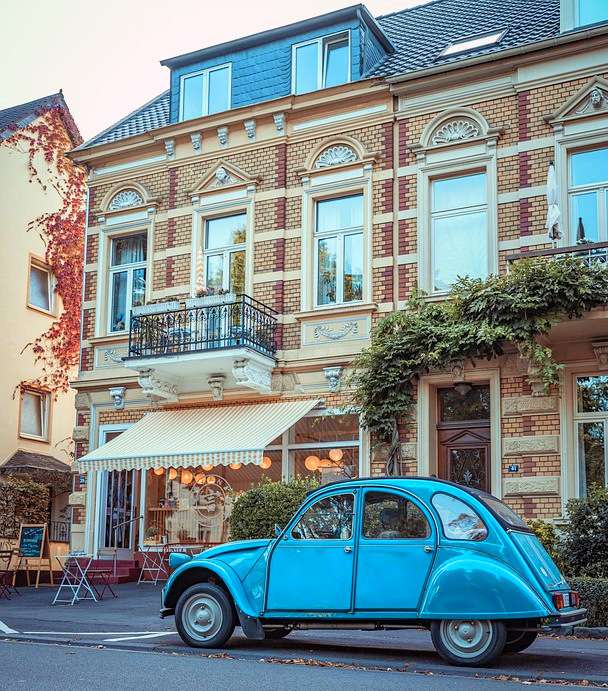 Un viejo Citroën frente a una casa de vecindad victoriana rompecabezas en línea
