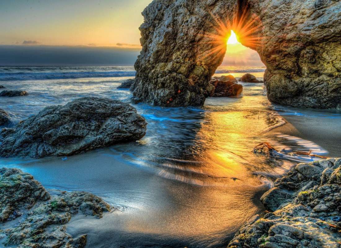 Ακτίνες του ήλιου που δύει σε μια σπηλιά βράχου παζλ online