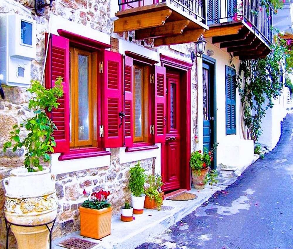 En gata med ett gammalt hyreshus och färgglada fönsterluckor Pussel online