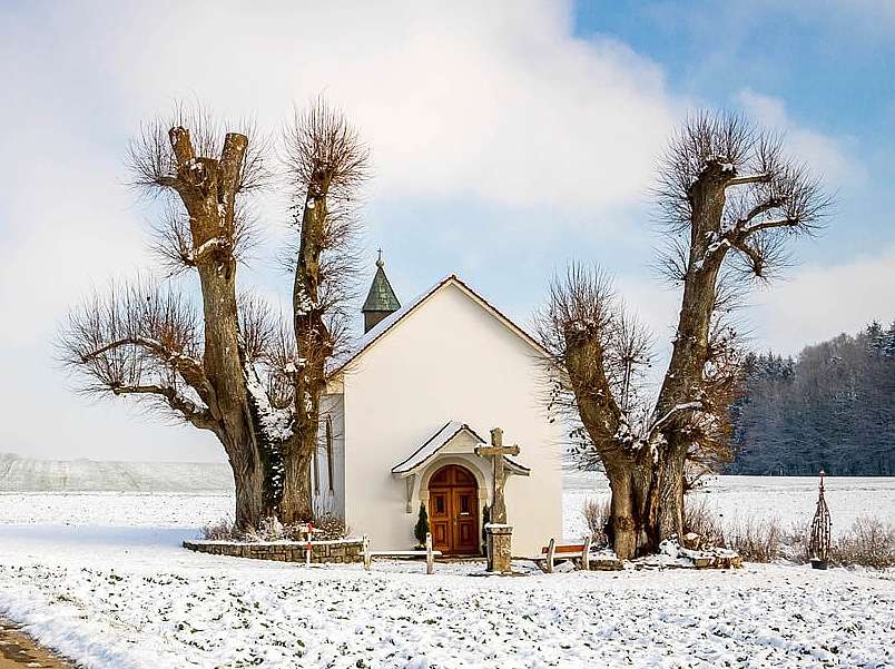 Un affascinante paesaggio invernale con una cappella puzzle online
