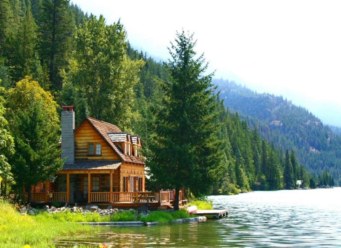 Casa di tronchi da un bellissimo lago puzzle online