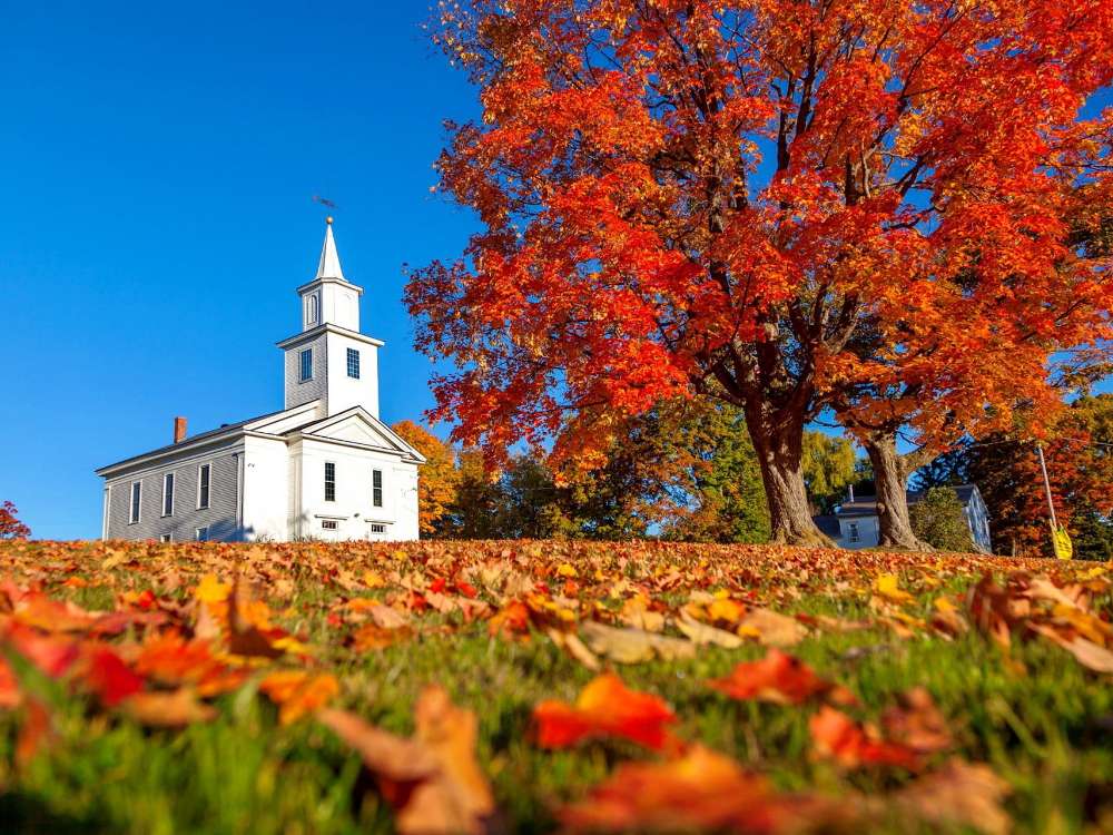 Una pequeña iglesia blanca en Nueva Inglaterra en otoño rompecabezas en línea