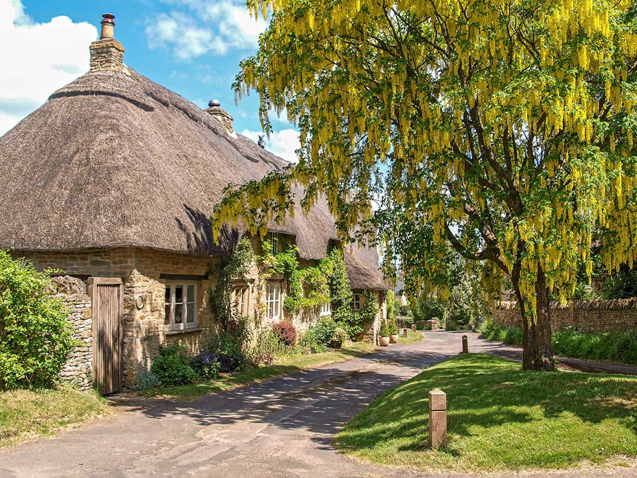 Un cottage inglese di campagna vicino a una strada di campagna puzzle online