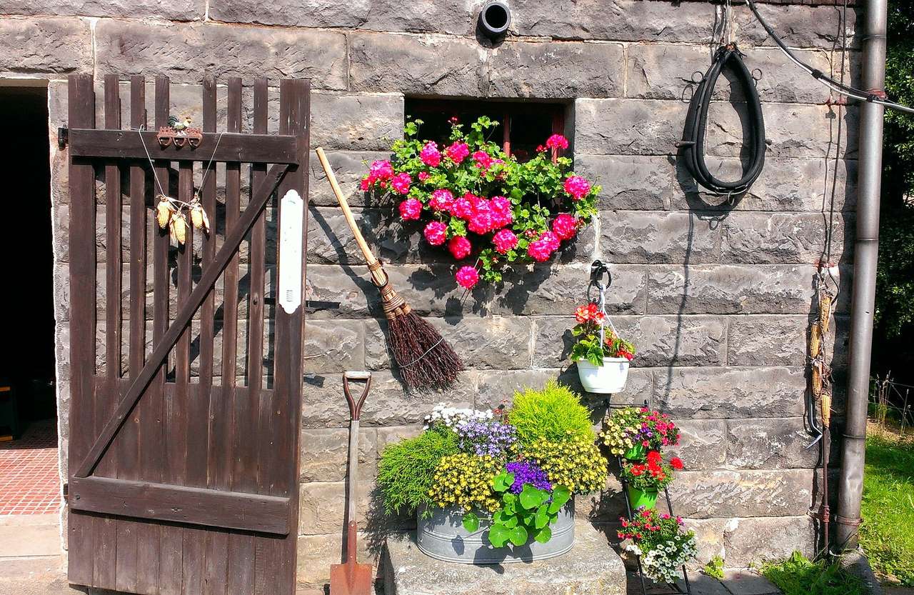 Mit Blumen geschmückt, ein Backsteinschuppen auf einem Bauernhof Online-Puzzle