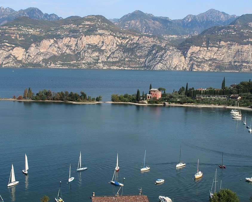 Campione. Águas azul-turquesa com barcos e montanhas quebra-cabeças online