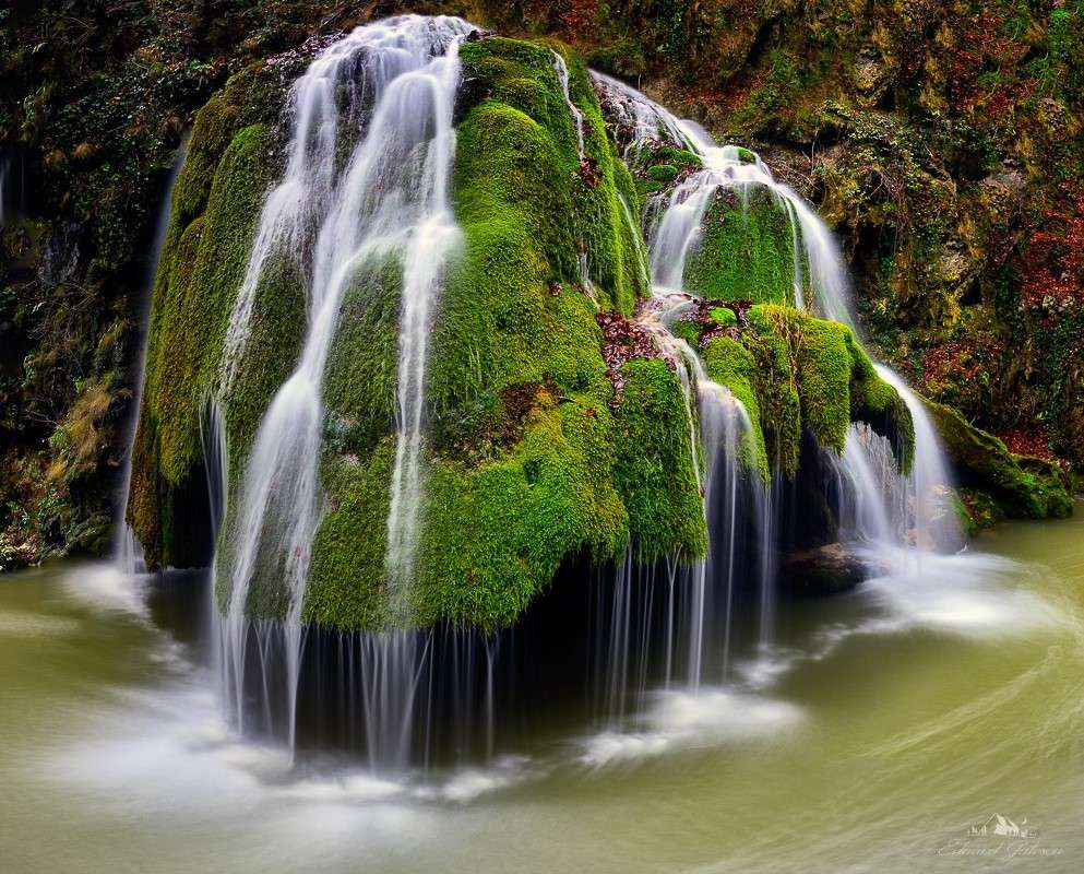 Uma pequena cachoeira e pedras cobertas de musgo quebra-cabeças online
