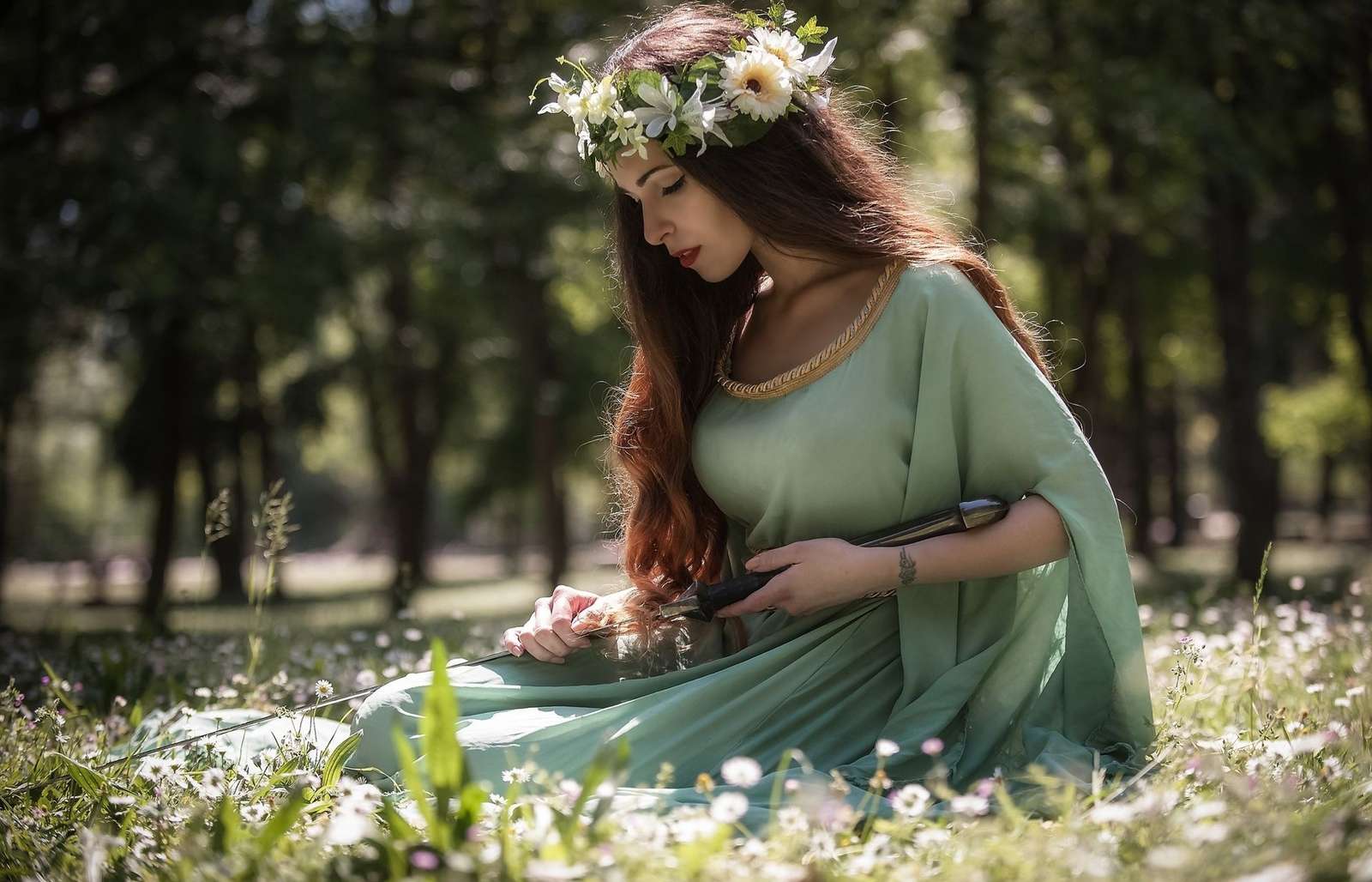 Una mujer en un prado con una corona de flores en la cabeza y una espada. rompecabezas en línea