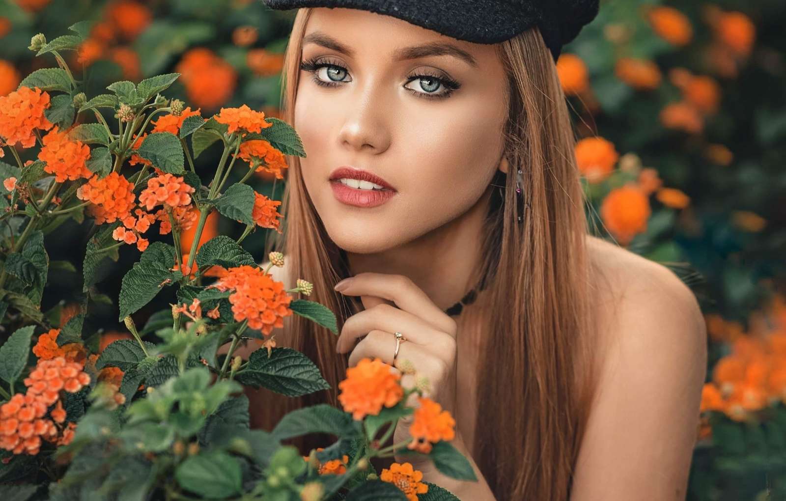 Flicka bredvid orange blommor Pussel online