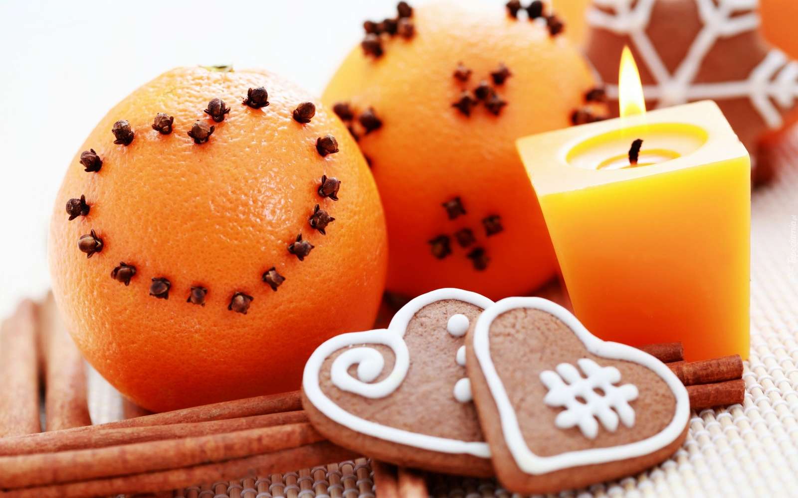 Sinaasappelen en peperkoeken naast een kaars en kaneel legpuzzel online