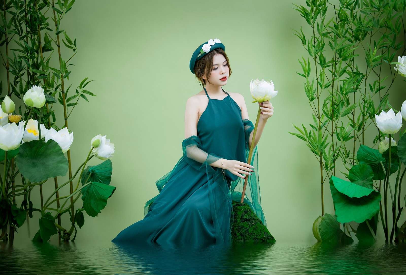 Aziatische vrouw in een groene jurk met een lotusbloem in het water legpuzzel online