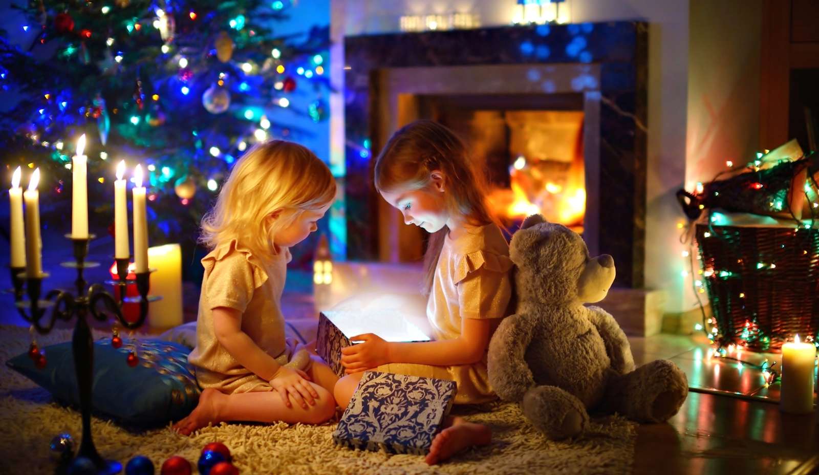 Bambini con doni sul tappeto accanto al caminetto puzzle online