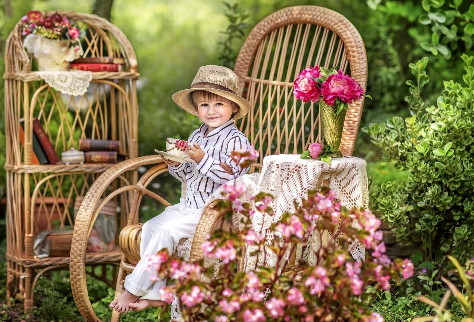 En pojke med en kopp te sitter i trädgården Pussel online