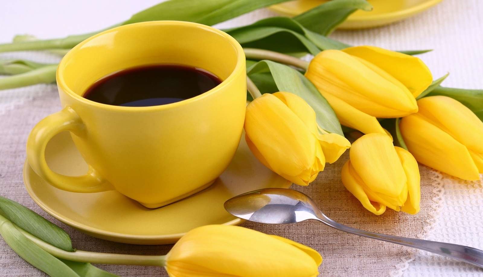 Taza amarilla y tulipanes. rompecabezas en línea
