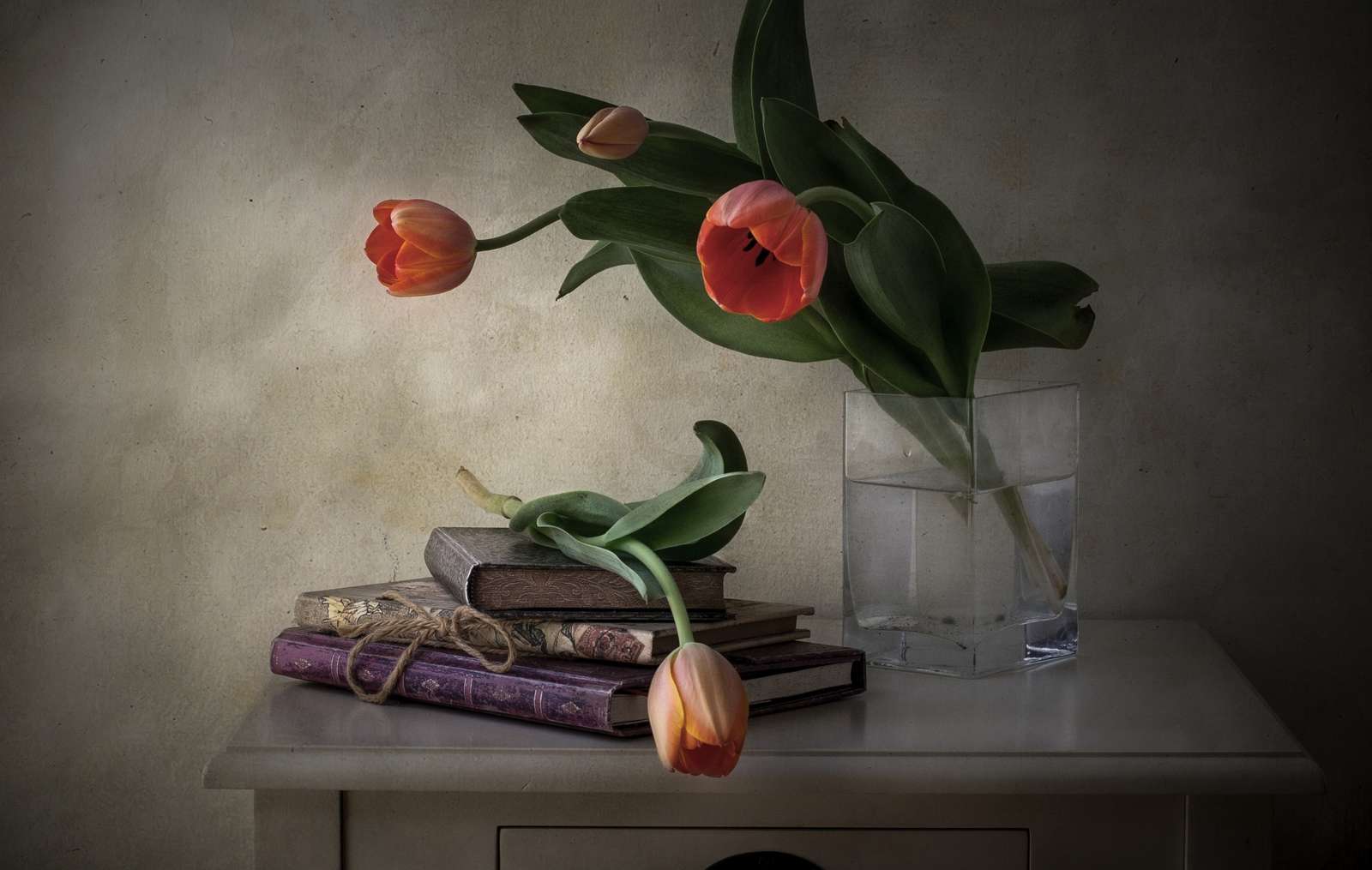 Libros junto a un jarrón con tulipanes. rompecabezas en línea