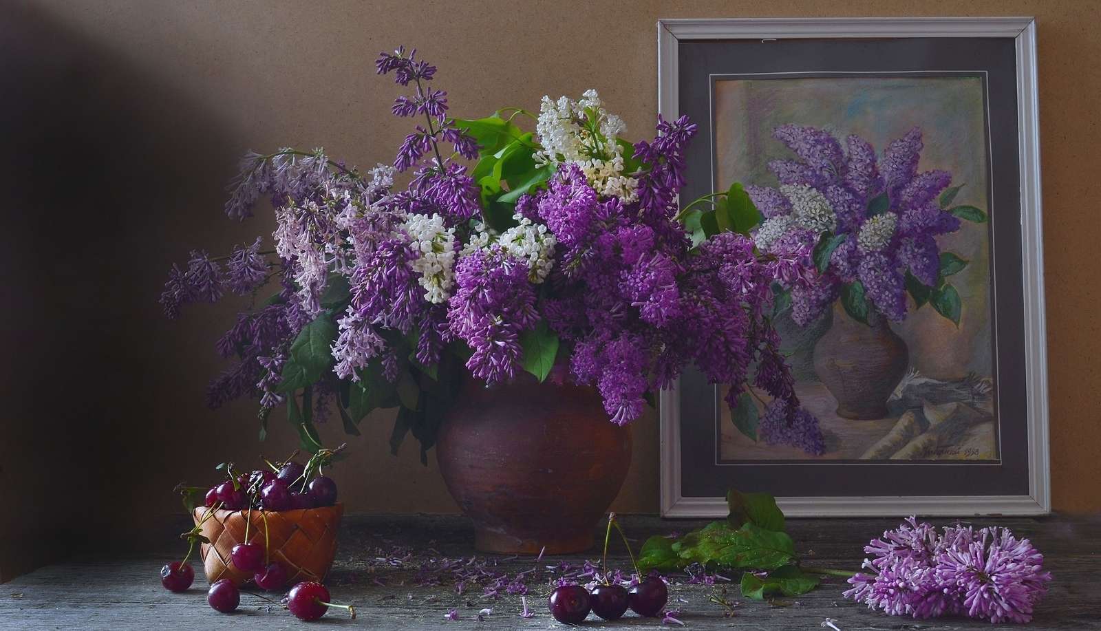 1Cerises dans un bol et une photo à côté d'un bouquet de lilas puzzle en ligne