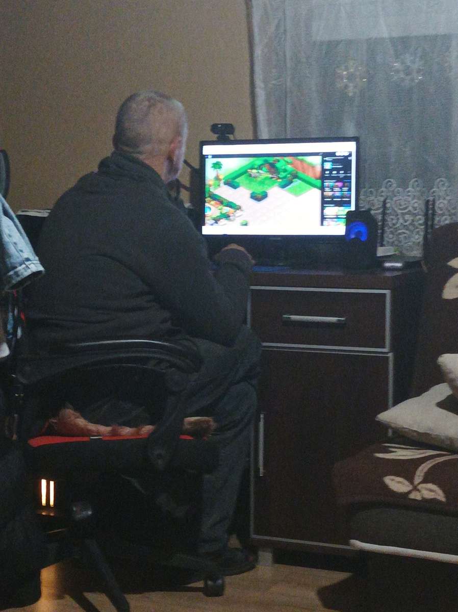 Mon père joue sur l'ordinateur puzzle en ligne