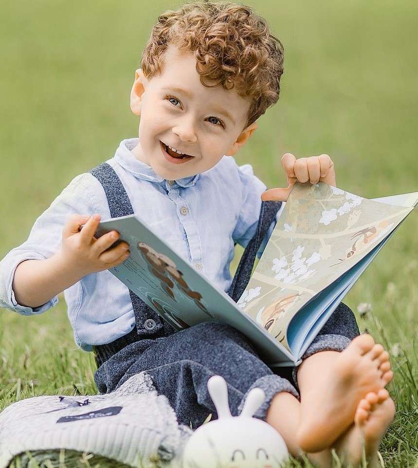 Un ragazzo seduto sull'erba con un libro puzzle online