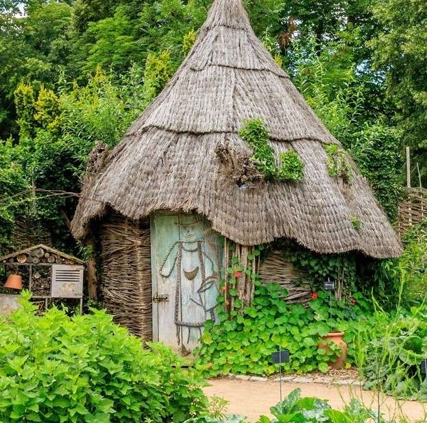 Une cabane dans le jardin au milieu des plantes et des arbres puzzle en ligne