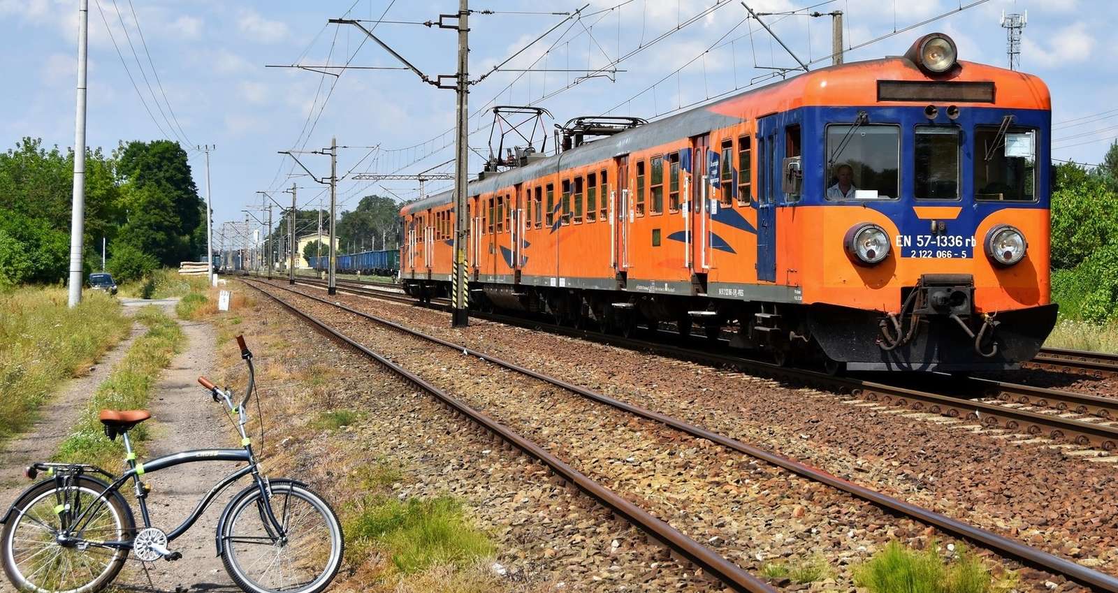 Orange train and bicycle on the tracks jigsaw puzzle online