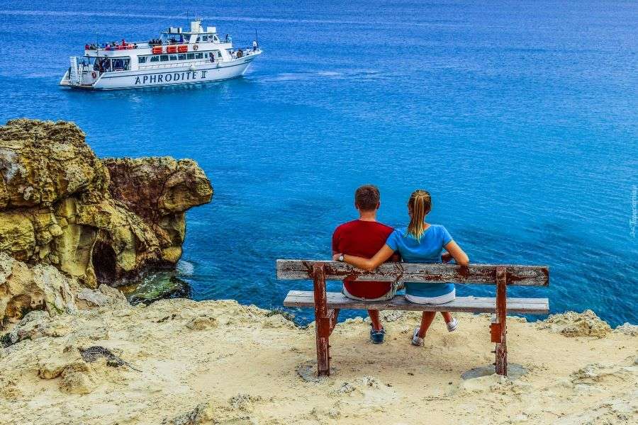 Un couple sur un banc et un bateau en mer puzzle en ligne