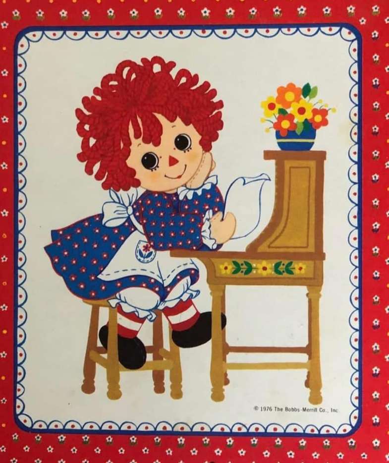 Raggedy Ann przy biurku z kwiatami. puzzle online